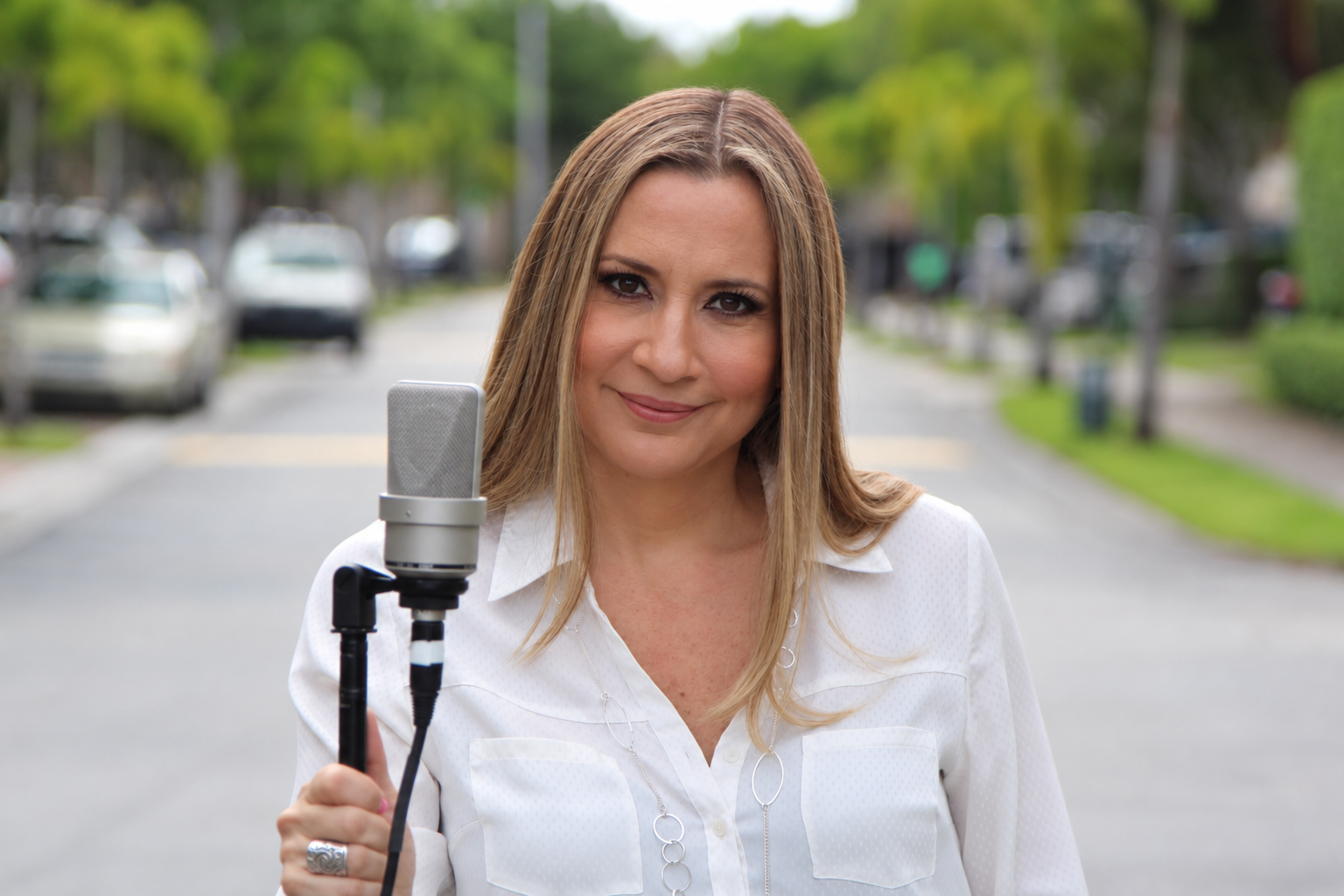 Cynthia Solís standing at a professional microphone